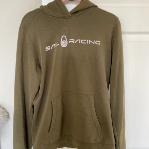 Grön Sailraising Hoodie - Grön Sail Rasing Hoodie Storlek: 170 cm Hoodien är skogsgrön med fickor fram.