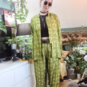 Set i siden, asiatisk stil - Set i 100% siden i asiatisk stil, från vietnam. Klar grön färg, med mönster. Byxor hellånga med resår i midjan. Skjorta med lång ärm och kanppar.  Fint skick