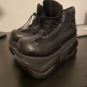 Demonia Boxer-01 Stompers/Plattåskor - Hej säljer mina demonia stompers då det var för stora för mig. Har använt de en kväll så det är i bra skick. Ordnarie pris var 1499 kr så säljer de för 1000 kr, den kommer i original låda. Går att hämta upp i Västerås eller postas