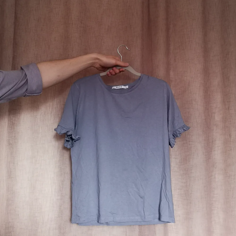 T shirt från Na-Kd, räfflade ärmar. Söt, gråblå färg. Säljes då den ej kommer till användning 🌞. T-shirts.