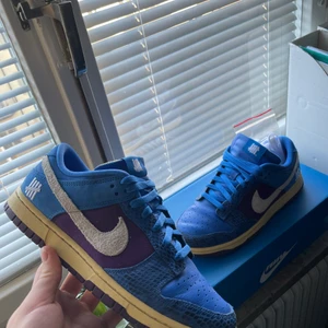 Nike UNDEAFTED  - Blåa och lila Nike Undefeated Dunks. Skorna är i storlek 42, och i väldigt bra skick. Använda mindre än 10 gånger. 