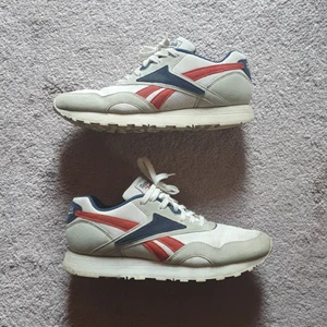 Reebok classics storlek 39 - Säljer mina välanvända Reebok sneakers i blått, rött och grått med läderdetaljer. Höger innersula har ett litet hål i ena kanten som behövs lagas, annars i fint skick! Frakt tillkommer ✨️