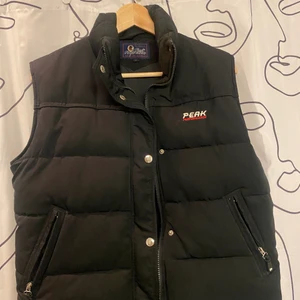 Vintage Peak väst - Säljer nu min jättefina dun peak väst då jag tyvärr inte längre har någon användning av den. Den är i storlek L barn, så skulle säga att den passar dig som har strl XS eller S. Sitter jättefint och är skötsamt använd .  Är inte säker på vad frakten hamnar på men skulle gissa att det blir 66