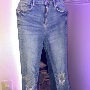 Blåa jeans med hål på knäna  - Det är ett par blåa jeans med hål på knäna, knappt använda! Priset kan diskuteras!