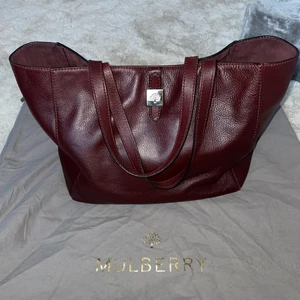Mulberry Tessie Tote i oxblod  - Beställd från Selfriges i London. Fick den i present av min fd pojkvän och vill där av inte ha kvar den. Den är äkta såklart men jag saknar kvitto dock finns serienummer på brickan i väskan som det alltid gör. Modellen finns inte längre att köpa hos mulberry. Den ett fack med dragkedja och ett öppet lytet fack på andra sidan inuti väskan. Går ej att knäppa ihop i mitten då pluppen för knäppningen lossnat. Inget som syns. Använd men i mycket fint skick. Dustbag tillkommer. 