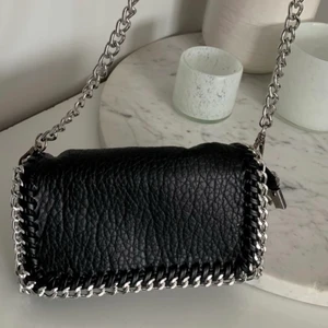 Svart tiamoväska  - Säljer min svarta tiamo kedjeväska! Minsta storleken, supersöt och kan både ha lång och kort kedja. 