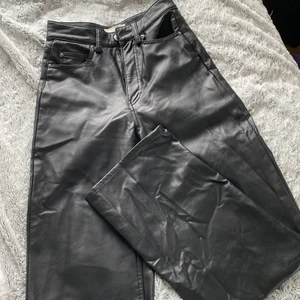 Läderbyxor - Säljer ett par sjukt snygga läderbyxor (fake) ifrån hm. Dom har lite slitage på ena bakfickan. Byxorna är mattsvarta (dom ser lite glansiga ut på bilderna). Har tyvärr blivit för små för mig. Köparen står för frakt.