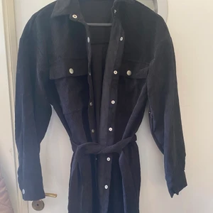 Skjortjacka - Svart skjortjacka med knappar och midjebälte. 