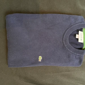 Lacoste - Använd 2 gånger, ser helt ny ut, inga fläckar eller någonting.  Fler bilder kan fixas