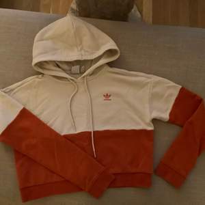 Beige/Orange hoodie från Adidas i storlek 34. Finns en liten fläck som går bort i tvätten, syns på bild