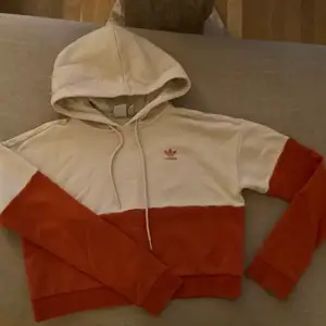 Beige/Orange hoodie från Adidas i storlek 34. Finns en liten fläck som går bort i tvätten, syns på bild