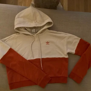 Adidashoodie - Beige/Orange hoodie från Adidas i storlek 34. Finns en liten fläck som går bort i tvätten, syns på bild