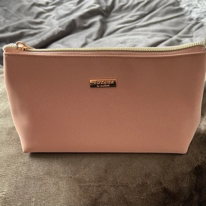 Necessär  - Liten necessär, perfekt när man inte vill ha med sig så mycket. Måtten är ungefär 20x12 cm. Lite sminkfläckar inuti. Den är gjord av 100% återvunnet material