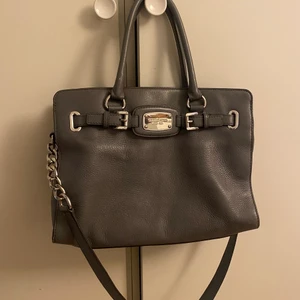 Michael kors handväska grå - Använd men i fint skick. Många fack. Något ljusare grå i verkligheten.