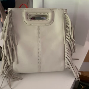 Maje väska  - Säljer min superfina Maje väska som jag inte får användning för så mycket, använd bara fåtal gånger. Vit/gräddvit i den mindre modellen, lång axelrem medföljer