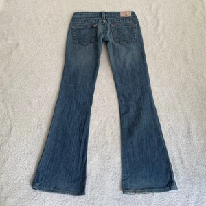 True Religion-jeans - ‼️BUDGIVNING PRIVAT, bud på: 610 + frakt‼️ Lågmidjade utsvängda jeans från True Religion, unika och perfekt passform! Jag är 173 cm, midjemåttet är 74 cm och innerbenslängden 80 cm ❤️‍🔥 