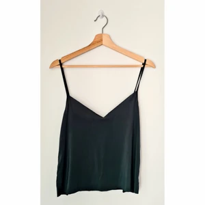 Mörkgrön topp  - En mörkgrön topp i polyester. Toppen är i storlek S men har lite stor urringning så skulle passa någon med lite större bröst. 