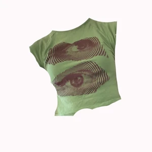 H&M - En grön gullig Tröja med svarta ögon 💋 tajt. Bra skick, använd några få gånger, jag säljer denna för att det inte är min stil längre, storlek S❤️