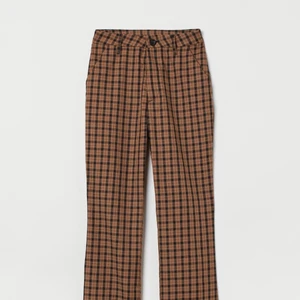 Utsvängda rutiga kostymbyxor - Utsvängda, högmidjade, brunrutiga kostymbyxor med slits. Använda en gång!