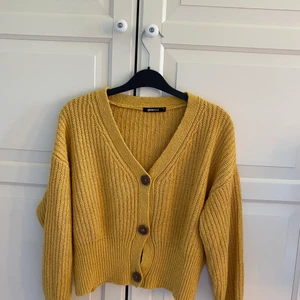 Stickad kofta - En stickad gul kofta med knappar. Mycket bra kvalitet!
