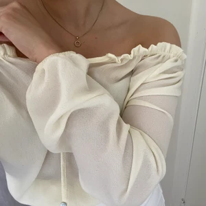 Topp med volangdetaljer - Sät topp som har volangdetaljer vid öppningen och går att knyta vid midjan. Benvit och i meshmaterial, så lite genomskinlig är den! Köptes från Fashionnova med tull