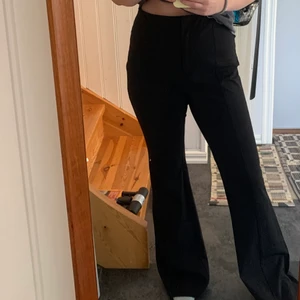 Utsvängda svarta kostymbyxor  - Utsvängda svarta byxor från monki strl 42. Materialet är väldigt stretchigt, långa i benen. 