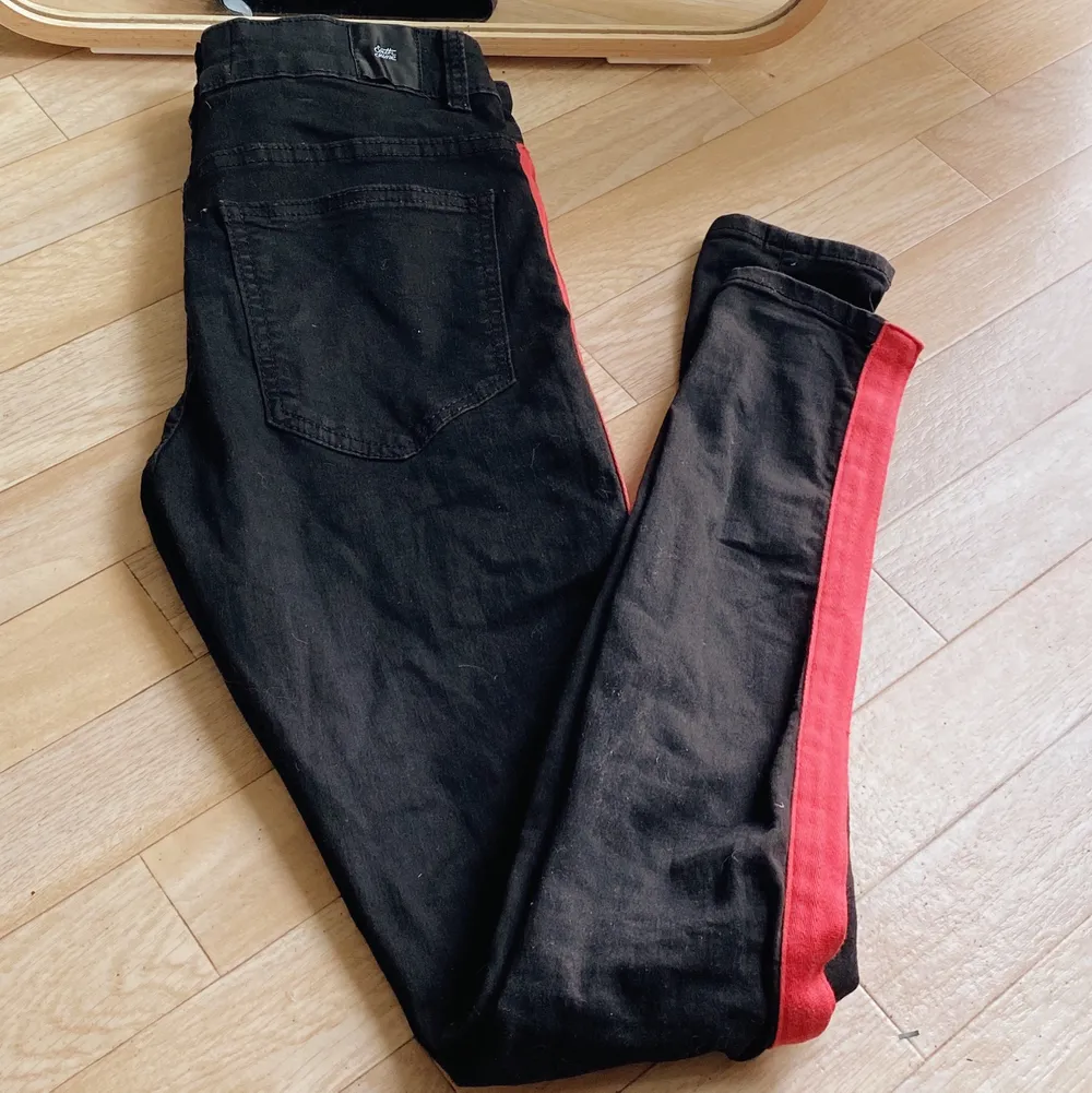 Svarta tajta jeans med rött streck, knäppe istället för dragkedja. Bra fickor både fram och bak! . Jeans & Byxor.