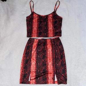 Rött snakeskin mönstrat crop-top linne & mini-kjol. Bekvämt material, stretchigt, tunnt & luftigt men inte see-through. Knappt använt!