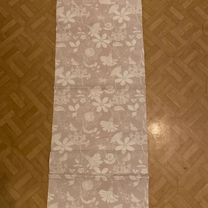 En liten bordsduk  - En liten bordsduk som har blommigt mönster. Mätte själv då lapparna inte var kvar.                                                               Längd ca: 96 cm.                                                                          Bred ca: 36 cm 😊