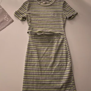 Klänning (strl. S) - En medelkort klänning från Behska i storlek S. Den går ungefär till över knäna. Den är öppen vid magen men inte för mycket! Färgerna är vit/grå/lime. Perfekt på sommar för tonåring! Nypris ca 200-300kr. Priset kan diskuteras!