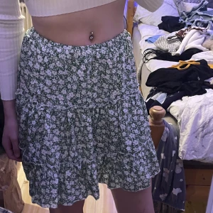 Jättefin blommig kjol - Jättefin grön blommig kjol från SHEIN. Aldrig använd och är i jättefint skick. Tunn och perfekt till sommaren. Den är i storlek xs och måste sälja den för att den är för liten.