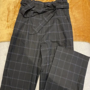 Finbyxor  - Rutiga paperbagbyxor eller slacks från Hm, ganska långa för de under 160. Aldrig använda pga längden. En mycket fin byxa i bra skick. I storlek 34 men passar 36. 
