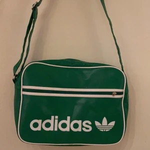 Adidas axelväska  - En grön Adidas vintage väska som man kan ha till lite allt möjligt. En snygg väska med mycket plats för både skolgrejer och annat i. 