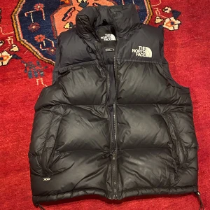 North Face väst  - Hej säljer denna fina väst i ett bra skick. Köptes för några års sen för 2500kr. Säljer för  1000kr, frakt ingår ej. Lägger upp på nytt då fläcken på baksidan gick bort med lite vatten 
