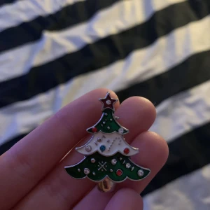 Ett hänge typ. - Det är en gran med mönster och lite vitt på. Super fin.