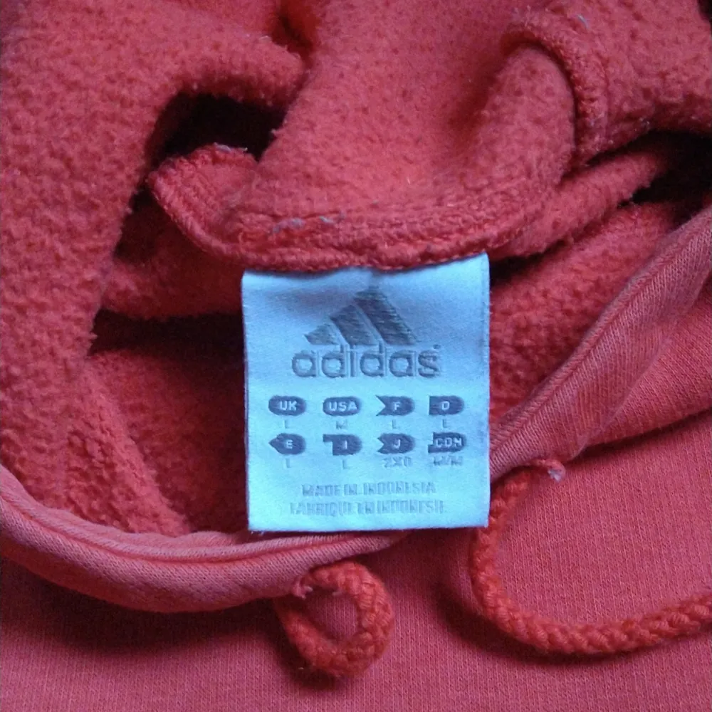 Adidas hoodie orange/röd i storlek L. Vintage skick men utan hål eller slitningar. Kan mötas runt Bagarmossen, Stockholm eller köparen betalar frakten!✨. Hoodies.