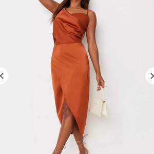 En brunt orange asymmetrisk klänning från Missguided, oanvänd, STRL: 36, (Frakt: 45kr)