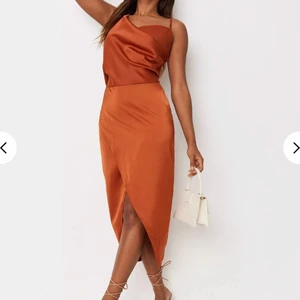 Brunt orange asymmetrisk klänning  - En brunt orange asymmetrisk klänning från Missguided, oanvänd, STRL: 36, (Frakt: 45kr)