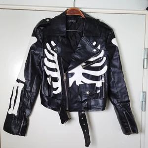 Skinnjacka - Jacka i bikermodell med skelettdetaljer! Finns ingen information i den men storleken är som en XS/S. Den är lite skavd vid halsen, men inget en lägger märke till🌱