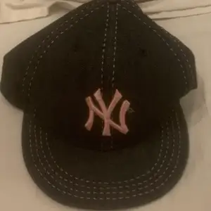 Feet yankees keps, mörk blå svart typ har liten svart färg fläck under kepsen.