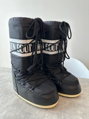 Moon Boots - Moonboots in Black, well kept and in excellent condition. Comes with accompanying shoe bag.   Original Retail Price: 1500kr Size: EU39-41 (This also fits you who are EU38) Purchased From: Nathalie Schuterman Butik