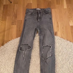 Gråa zara jeans med slits och hål - Gråa jeans från zara med slits, använda