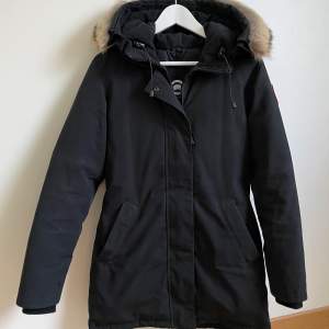 Säljer min Canada Goose i modellen Victoria Parka, storleken XS (passar S). • Figurnära passform  • Tvåvägsdragkedja  • Avtagbar äkta pälskant  • Lårlång längd   Nypris 10 190kr Mitt pris 7 110