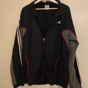Träningsjacka från Adidas - Trendig träningsjacka. Köptes ihop om användning med så blev ej fallet..