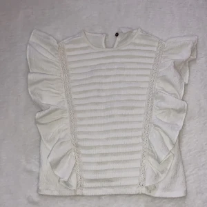 Vit/volanger på sidorna - Vit volangtröja oanvänd./