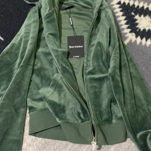 Helt ny Juicy Couture kofta - Den e helt ny har aldrig använt den men den har inget öppet köp så kan it lämna tbx. vill it ha mindre än 1000 för den då den är helt ny och aldrig använd. Prislappen är på och plasten på dragkedjan.