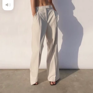 Beiga kostymbyxor  - Säljer dessa fina vida beiga kostymbyxorna i storlek S. Sitter lite högre i midjan och dom är jättelånga i benen. 