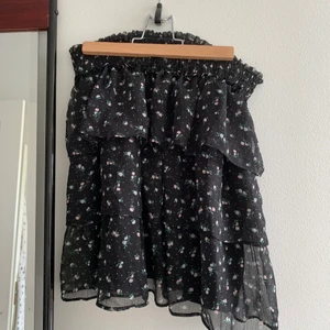 HM kjol strl S - Svart kjol med små blommer från hm , strl s andvänd 1 gång , den passade inte mig så kom inte till andvändning, supper trendig, för mer bilder kom privat