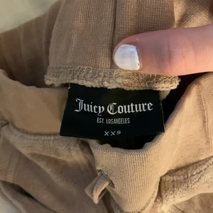 Juicy Couture beige  - Säljer mina juicy couture (bara byxorna) köpta helt nya, dem är väl använda men ändå bra skick. En av knapparna funkar inte att sätta fast men det är inget som syns.