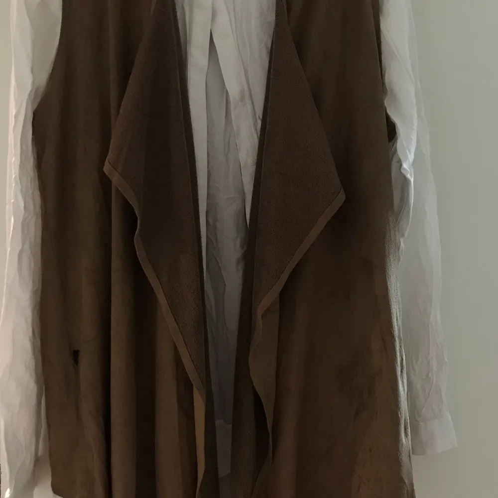 Sammetstyget är en kamelbrun färg som bärs på hösten under en skjorta, men skjortan är inte till salu. Stickat.